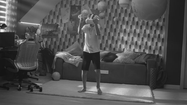 Still from Canon: Knocked Out (2024), directed by Michael S.U. Hudson: a boy in a virtual reality headset shadow boxing in his bedroom